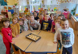 Grupa dzieci z upieczonymi chlebkami.